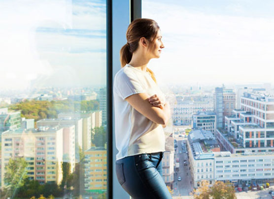 Femme regardant la ville par la fenêtre