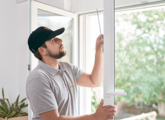 Un technicien de service examine la ferrure de fenêtre