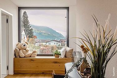 Innenaufnahme eines festverglasten Holz/Aluminium-Fensters EgoAllstars mit tiefer Leibung, die gleichzeitig als Sitzgelegenheit dient