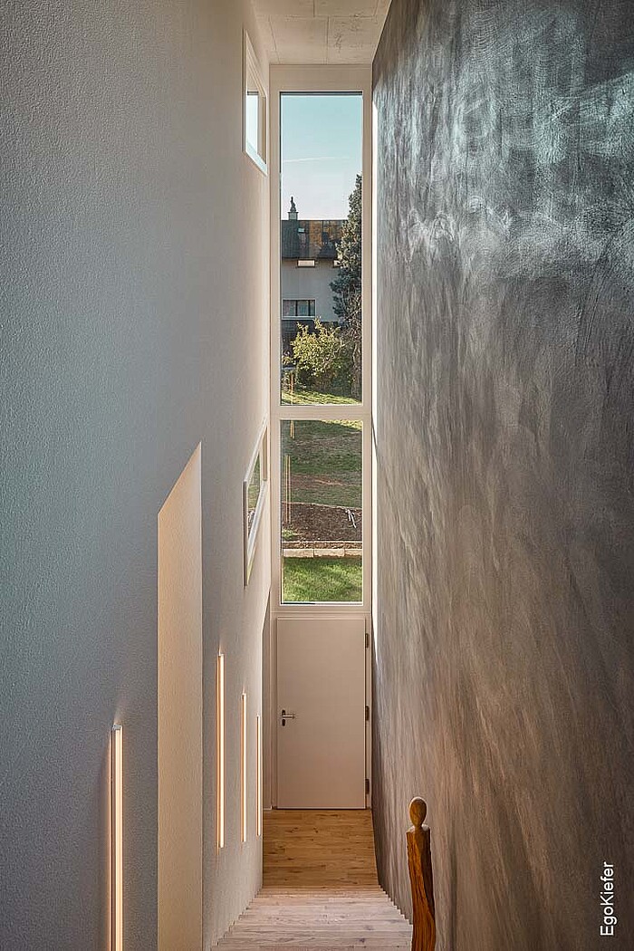 Vue intérieure d'une maison pour deux familles à Düdingen, avec une porte d'entrée de l'intérieur et un vitrage fixe 