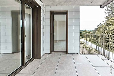 Aussenaufnahme, überdachte Terrasse mit Fliesenboden, links sind grosse Hebeschiebetüren sichtbar 