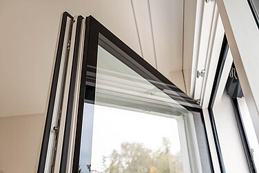 Detailaufnahme eines Holz/Aluminium-Fensters, Flügel offen, Stufenglas sichtbar