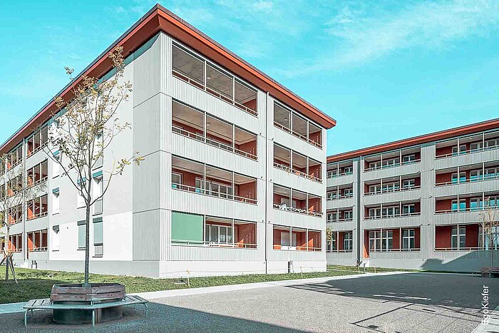 Vista esterna di due moderni condomini del complesso residenziale Scheidegg a Steffisburg Bern con linee chiare, ampi balconi e Piazzale piantumato