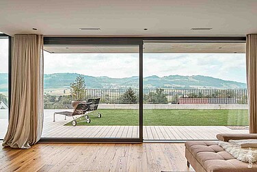 Innenaufnahme eines Einfamilienhauses in Muri, EgoKiefer Holz/Aluminium-Hebeschiebetüren XL<sup>®</sup>2020 sichtbar