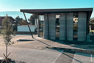 Aussenaufnahme des ersten vollständig im 3D-Betondruck gefertigten Gebäudes mit EgoKiefer Holz/Aluminium-Fenstern EgoAllstar