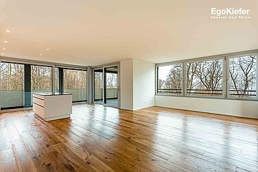 Innenaufnahme des Wohnzimmers/Küche mit grossen Holz/Aluminium-Fenstern und Hebeschiebetüren mit wunderschönem Blick nach Draussen