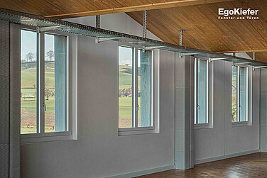 Innenaufnahme der neuen Produktionshalle der Lanz-Anliker AG, mit vier 2-flügligen Holz/Aluminium-Fenstern im Bild