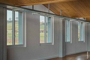 Innenaufnahme der neuen Produktionshalle der Lanz-Anliker AG, mit vier 2-flügligen Holz/Aluminium-Fenstern im Bild