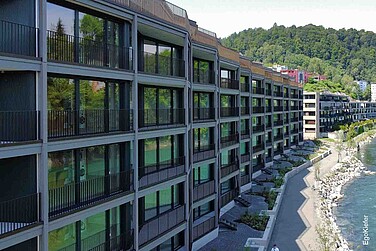 Aussenaufnahme des Mehrfamilienhauses mit Sicht auf die Reuss, mit grossen, geschosshohen Holz/Aluminium-Fenstern EgoAllstar und EgoSelection