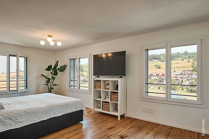 Dall'interno della camera da letto, tre finestre in PVC/alluminio lasciano entrare molta luce naturale