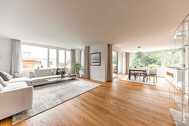 Innenaufnahme im Wohnzimmer mit grossen Glasfronten und Hebeschiebetüren für maximalen Lichteinfall