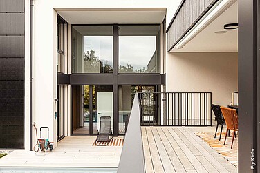 Moderne Glasfassade mit Blick auf Terrasse, Pool und Sitzbereich