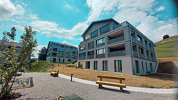 Aussenaufnahme der Wohnüberbauung "Ochsenwies" in Waldstatt AR, zwei Mehrfamilienhäuser sichtbar