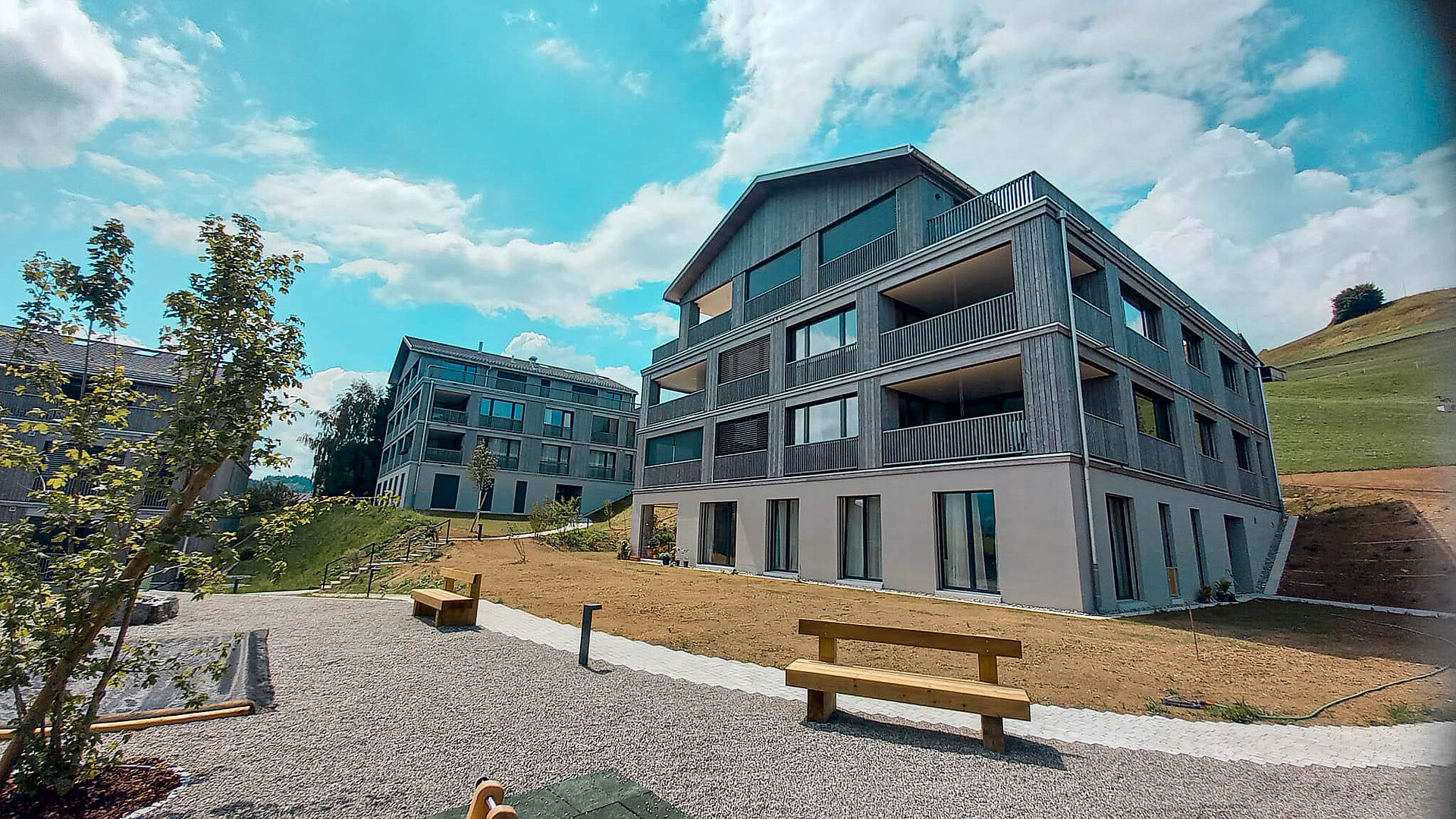 Aussenaufnahme der Wohnüberbauung "Ochsenwies" in Waldstatt AR, zwei Mehrfamilienhäuser sichtbar