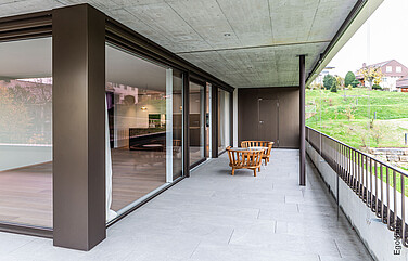 Foto dell'esterno del condominio Erli a Lyss, con la porta scorrevole a sollevamento in PVC/alluminio 88 nella vista XL 