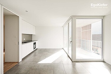 Vista dell'interno del condominio "Residenza al Sasso", foto della cucina, a destra con finestre in legno/alluminio EgoKiefer EgoAllstar, due ante a vetro fisso