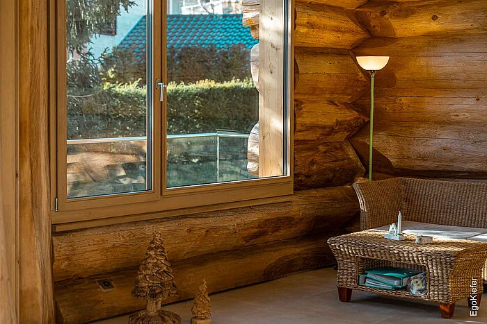 Photo d'intérieur d'une nouvelle construction moderne de style blockhaus à Amden, St-Gall, avec un intérieur en bois clair et des fenêtres en bois EgoWoodstar EgoKiefer de haute qualité, qui créent une atmosphère d'habitation douillette.
