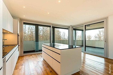 Innenaufnahme einer Wohnung des Wohnblocks Seemoosholz in Arbon, Bild in der Küche mit zwei grossen Hebeschiebetüren aus Holz/Aluminium