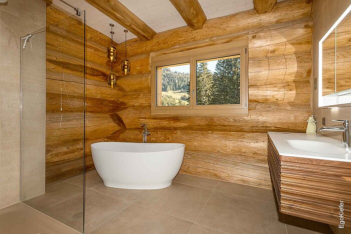 Innenaufnahme eines modern gestalteten Badezimmers mit hochwertigen Holzfenstern EgoWoodstar und Blick nach draußen, die für Helligkeit und stilvolle Eleganz sorgen.
