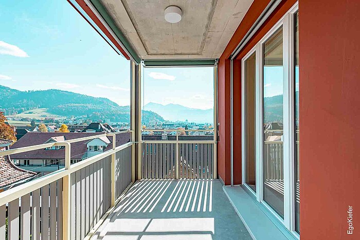 Vista esterna del complesso Scheidegg alla luce del giorno, con ampi balconi e splendida vista sull'Oberland Bernese