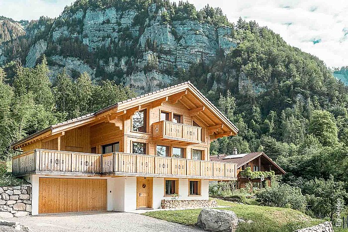 Aussenaufnahme eines attraktiven Holzhauses in Schwanden, im Hintergrund eine imponierende Naturkulisse