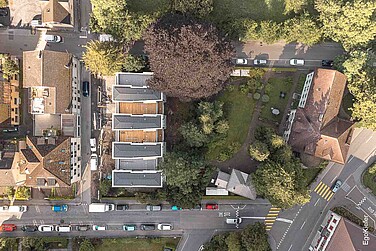 Vogelperspektive mit Sicht auf den Park Freienstein, Glarus mit vier neuen Reihenhäusern, Villa Freienstein und dem Atelier