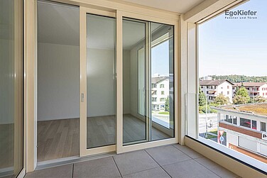 Innenanaufnahme Loggia, Fenster und eine Hebeschiebetüre sichtbar, Zentrumsüberbauung «Grossmatte West», Littau/Luzern