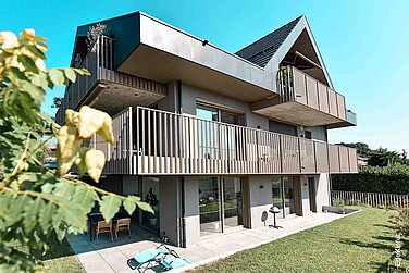 Aussenaufnahme eines Mehrfamilenhauses in St-Prex, mit Kunststoff/Aluminium-Fenstern EgoAllround und Hebeschiebetüren 76 in XL-Optik