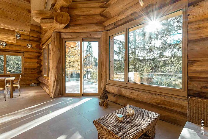 Detailaufnahme von hochwertigen Holzfenstern EgoWoodstar in einem modernen Wohnraum, die natürliches Licht hereinlassen und den Raum wohnlich gestalten.