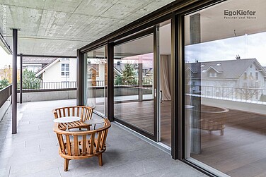 Foto dell'esterno del condominio Erli a Lyss, con la porta scorrevole a sollevamento in PVC/alluminio 88 nella vista XL 