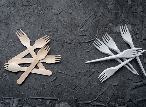Fourchettes en bois et en plastique sur une surface sombre