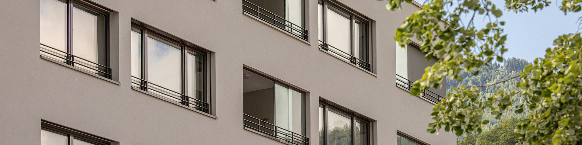 Naturfarbener moderner Wohnblock mit grossen Fenstern