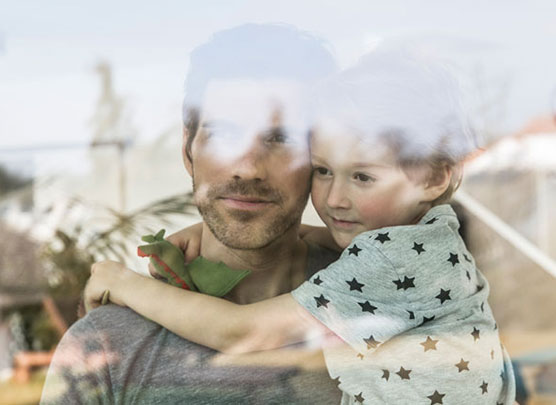 Vater hinter Fenster mit Kind