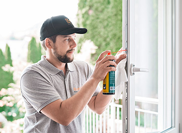 EgoKiefer Servicemonteur sprüht Beschlagsmittel in Fensterbeschlag