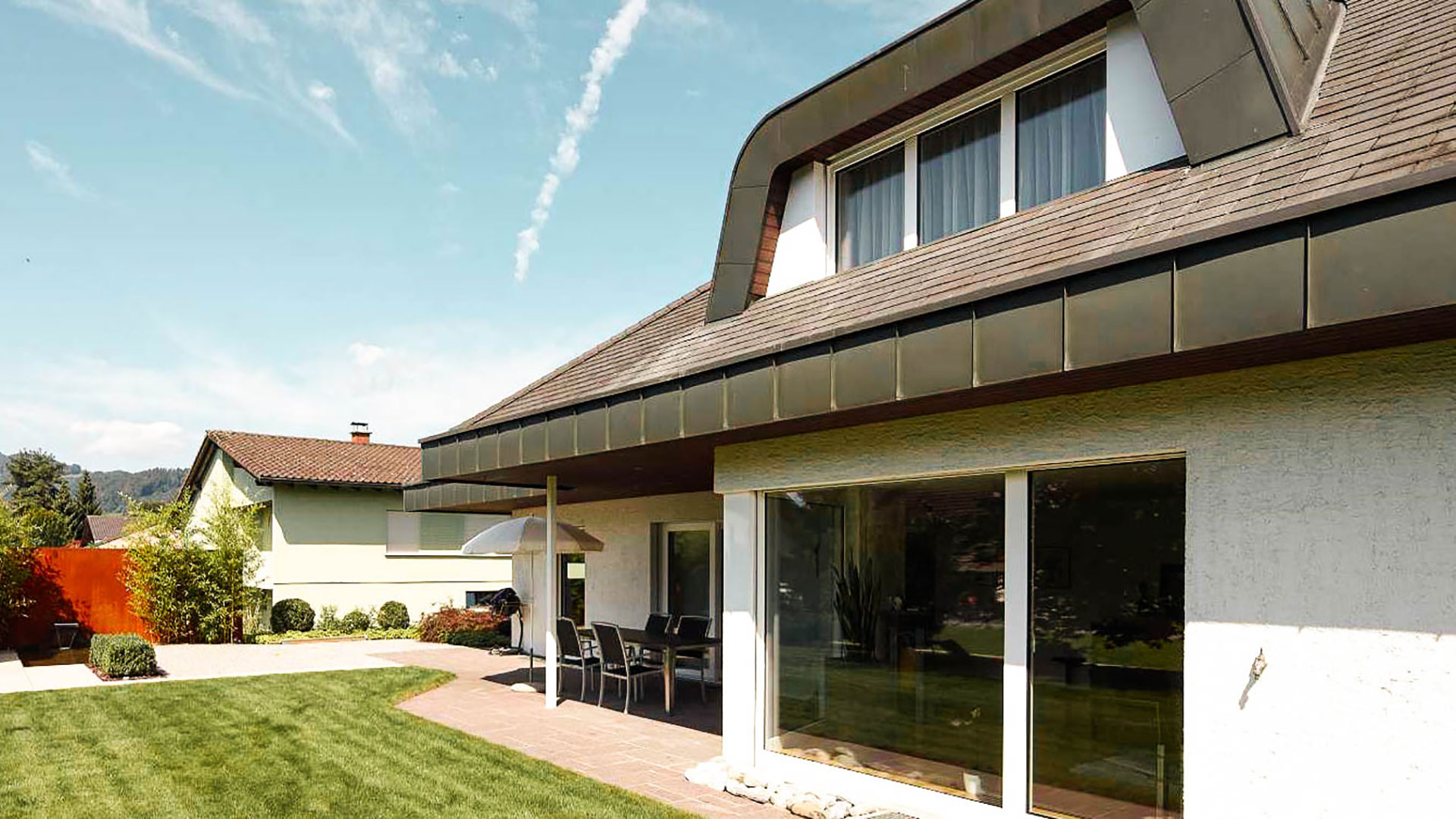 Fotografia esterna della casa unifamiliare Hasler Widnau, balcone e porta scorrevole anteriore e finestra visibile al piano superiore