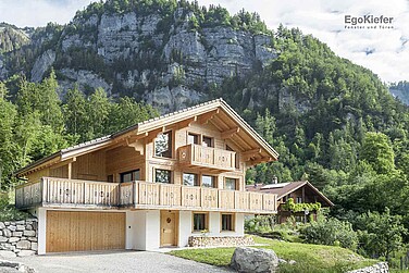 Aussenaufnahme eines attraktiven Holzhauses in Schwanden, im Hintergrund eine imponierende Naturkulisse